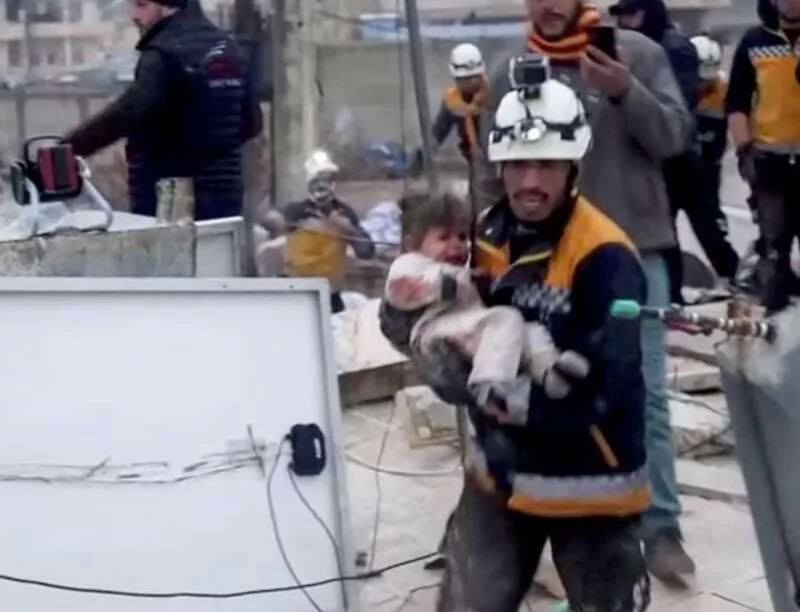 一名救援人员在叙利亚从倒塌建筑的废墟中抬离一名儿童