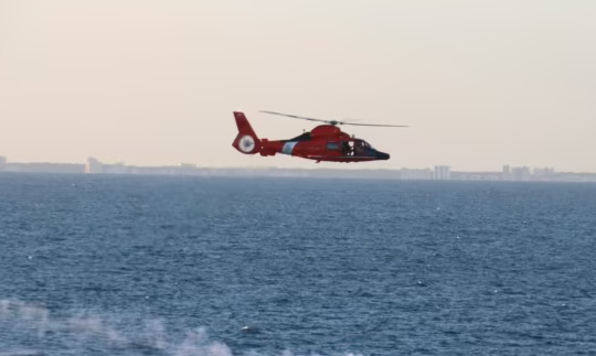 美国海岸警卫队直升机在回收中国高空侦察气球残骸行动期间飞过碎片散落区 ... ...